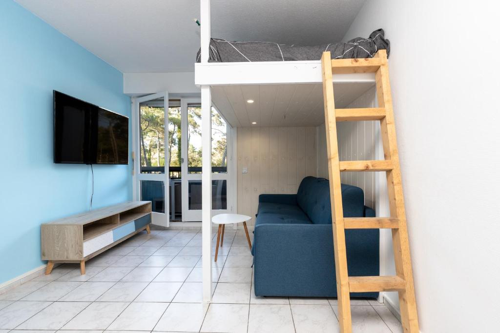 塞尼奥斯Studio Seignosse proche plage的客房设有双层床、沙发和梯子。