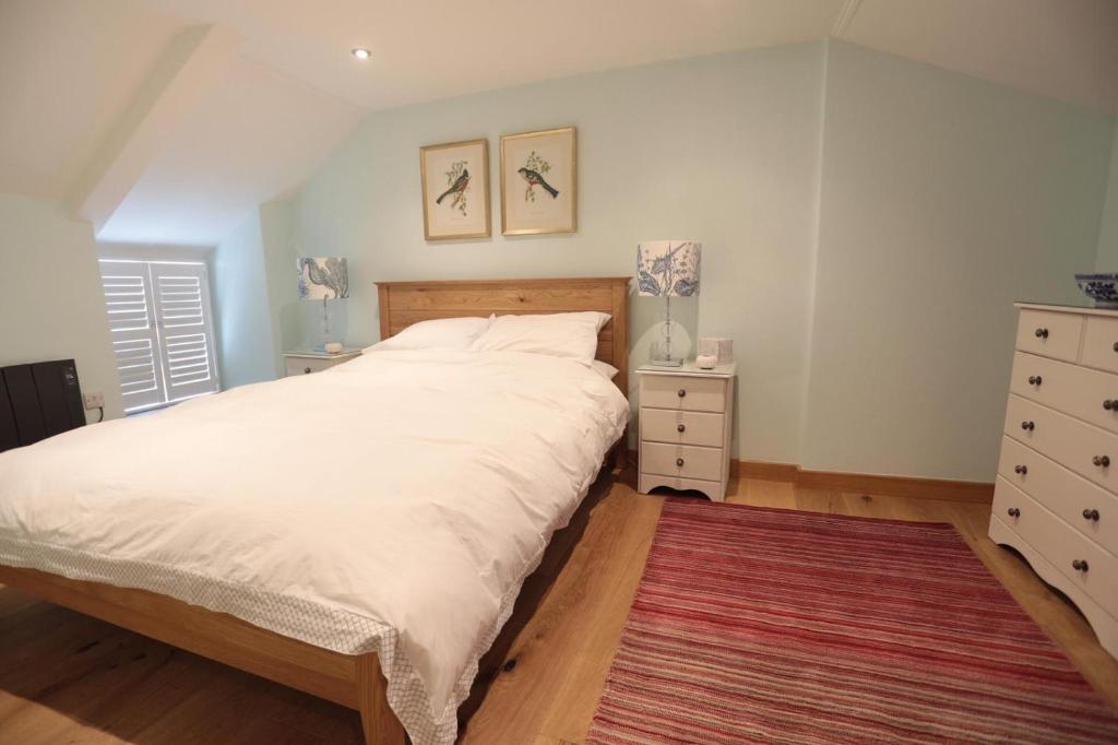 圣贾斯特Cobble Cottage的卧室配有一张白色大床和地毯。
