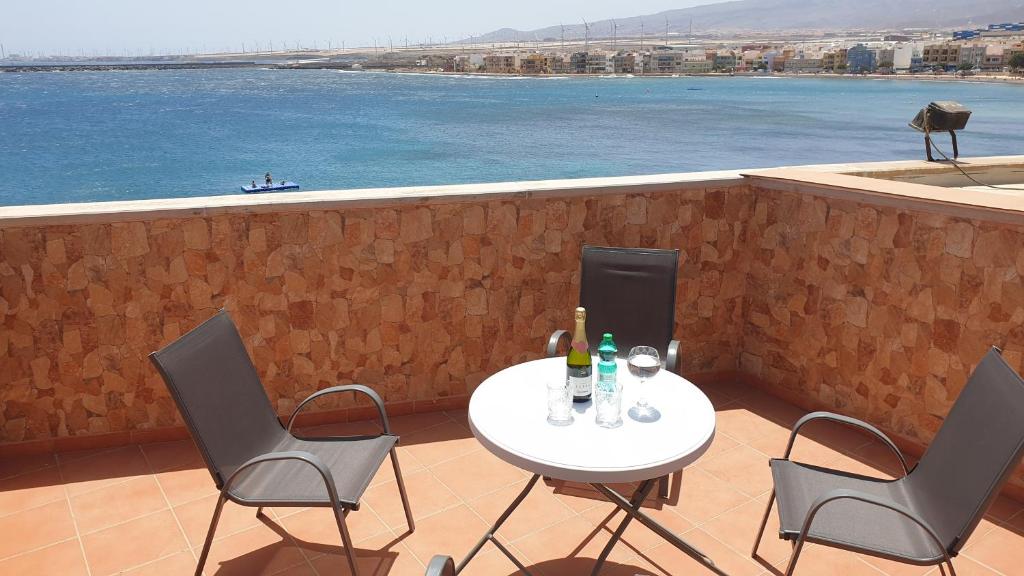 阿里纳加CanariasBrisaMar - Apartamento的阳台配有桌椅,享有水景
