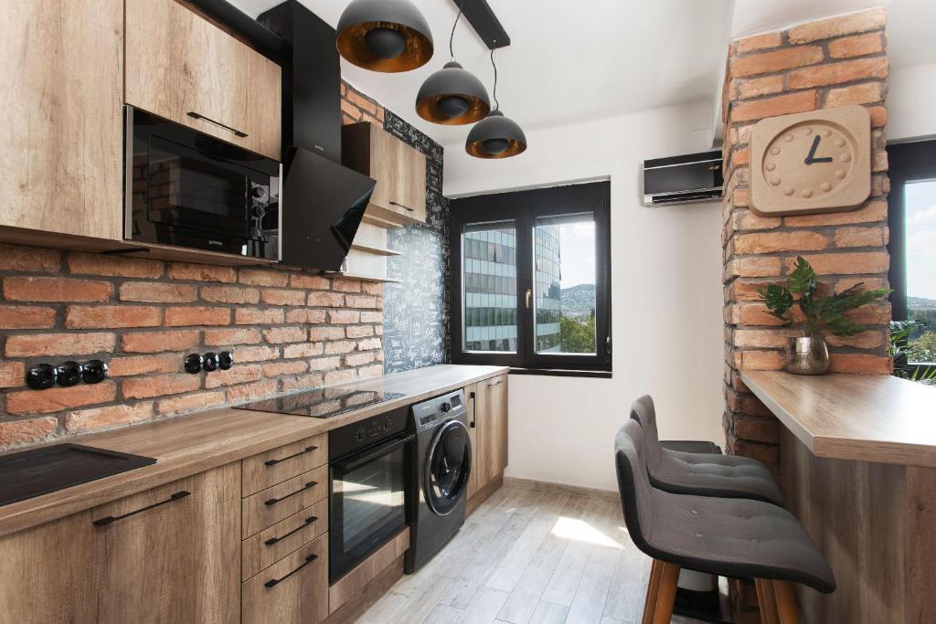 布达佩斯Industrial Studio的厨房配有木制橱柜和砖墙