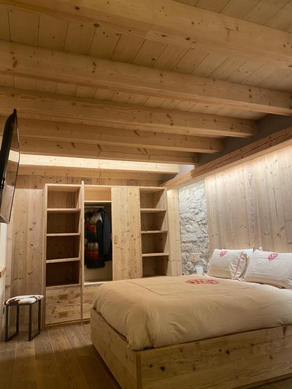 加廖Il Falco Affittacamere的一间卧室设有一张大床和木墙
