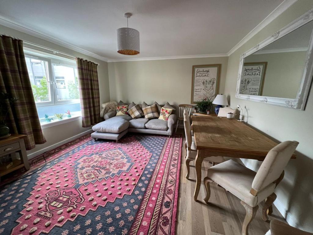 爱丁堡Holyrood Duplex 3- Bedrooms Apartment的客厅配有桌子和沙发