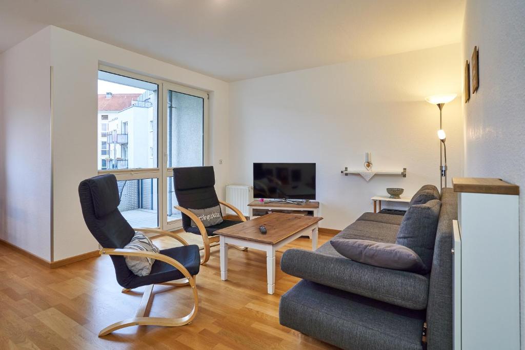 德累斯顿Apartment Sun Balcony Dresden Friedrichstadt的客厅配有沙发、椅子和电视