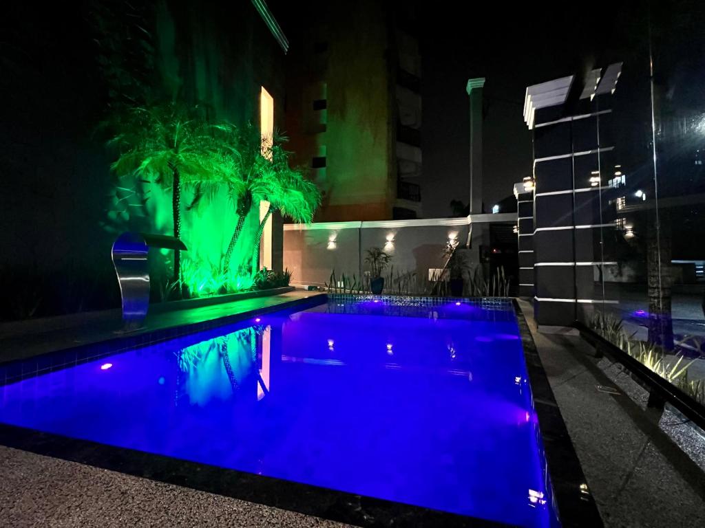 瓜鲁雅Marmeu Tombo com Hidro Aquecida Privativa的夜晚的游泳池,灯光蓝色