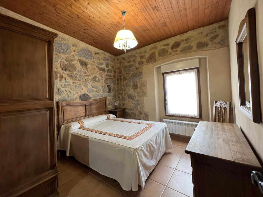 阿维拉Casa La Colmena Ávila的一间卧室设有一张床和一个窗口