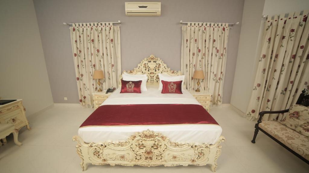 卡拉奇Four Squares Karachi的卧室配有1张特大号床和红色枕头