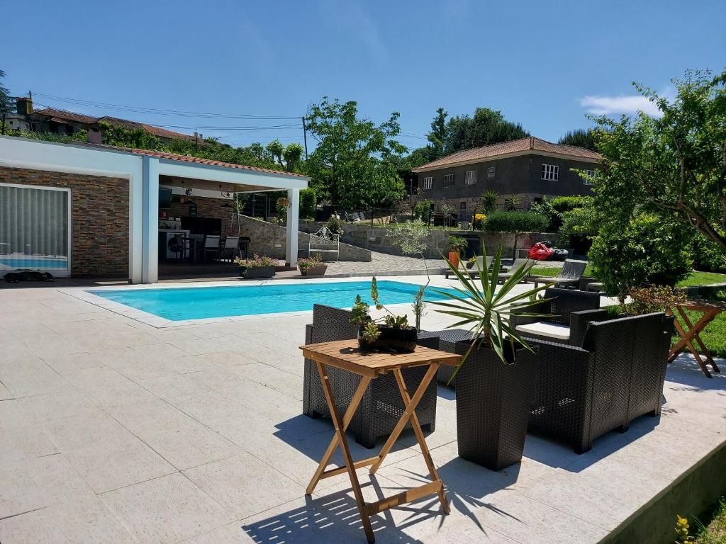 马尔科-德卡纳维泽斯Villa Casa de Santo Antonio的一个带桌椅的庭院和一个游泳池