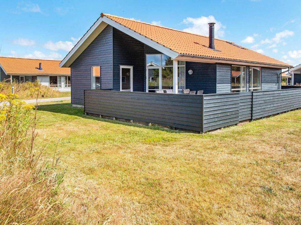 乌尔夫堡Holiday home Ulfborg XXII的前面有大草坪的黑色房子