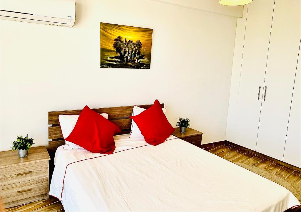 拉纳卡BALI SUITES 303的一间卧室配有红色枕头的床