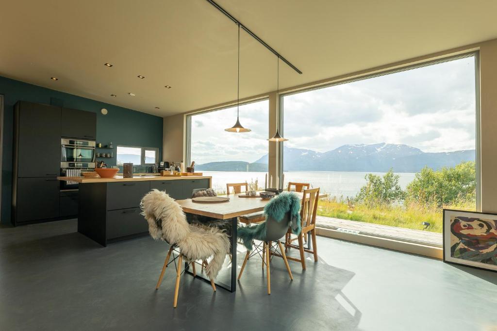 MortenhalsIndulge in beautiful nature and amazing views.的一个带桌椅和大窗户的厨房