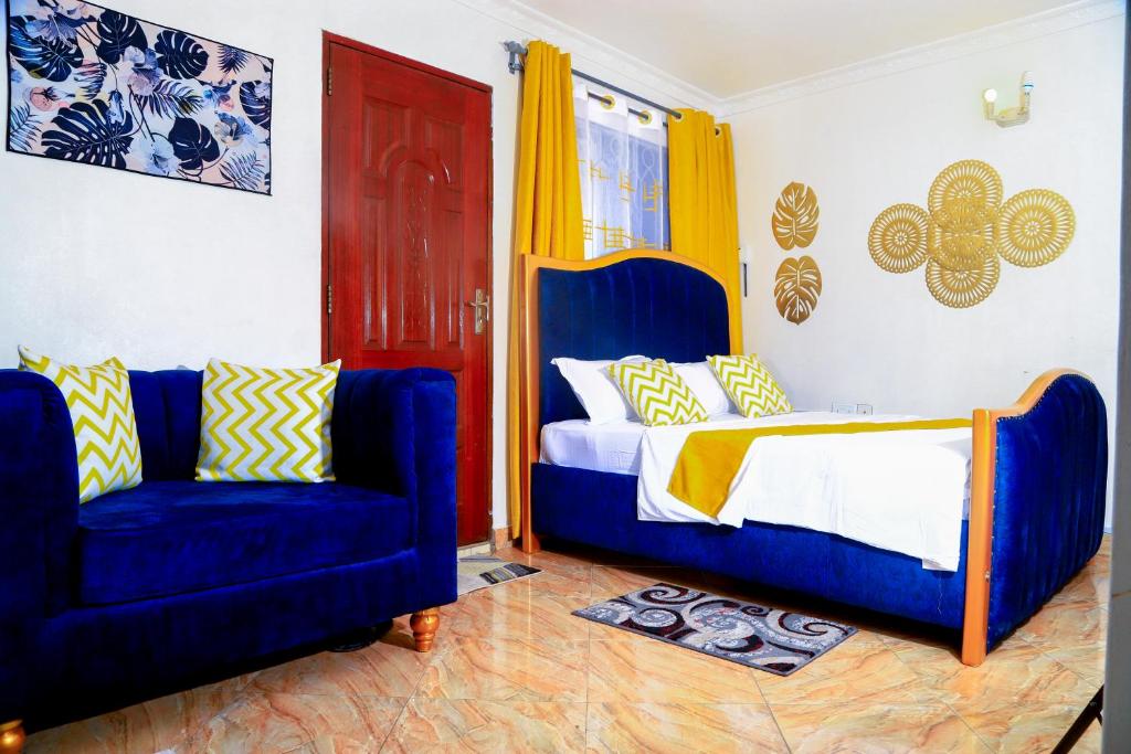 蒙巴萨Royal Haven A1 Apartment in Mombasa - Bamburi, 50" HDTV, WiFi, 6 mins to Beach的一间卧室配有一张床和两张蓝色椅子