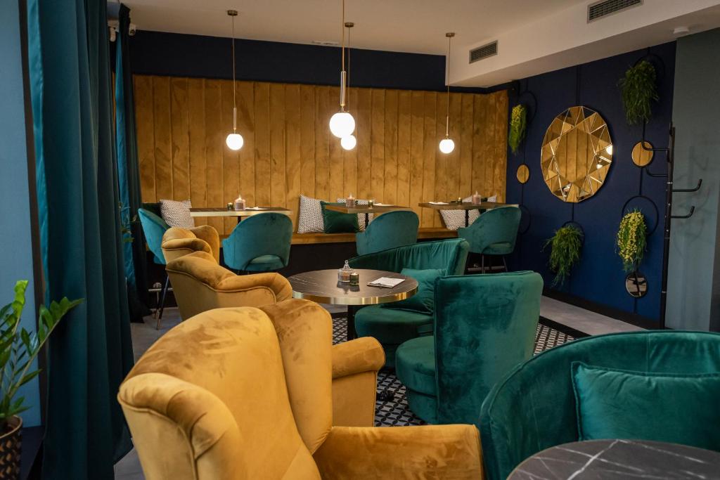 GiraltovceHotel Alfa的一间餐厅,房间内设有绿色的椅子和桌子