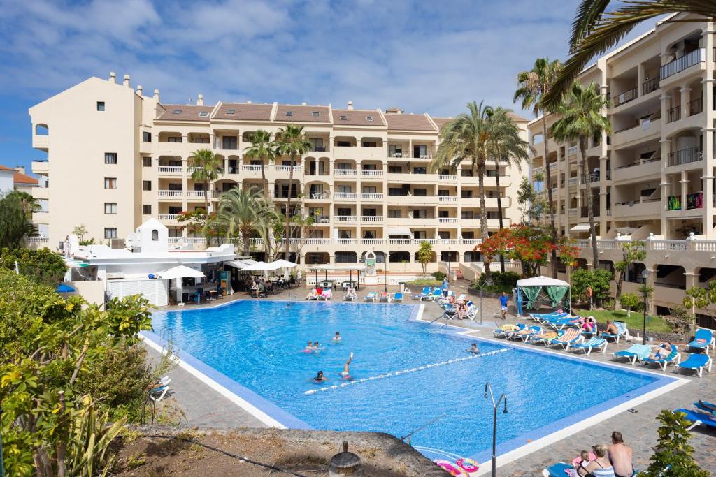 洛斯克里斯蒂亚诺斯Home2Book Charming Castle Harbour Los Cristianos的酒店前方的大型游泳池