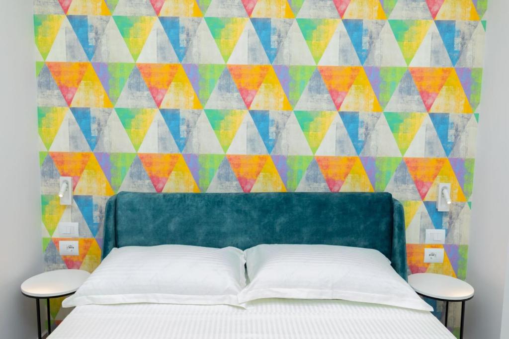 希马拉Corallo Rooms的一间卧室设有一张床和色彩缤纷的墙壁