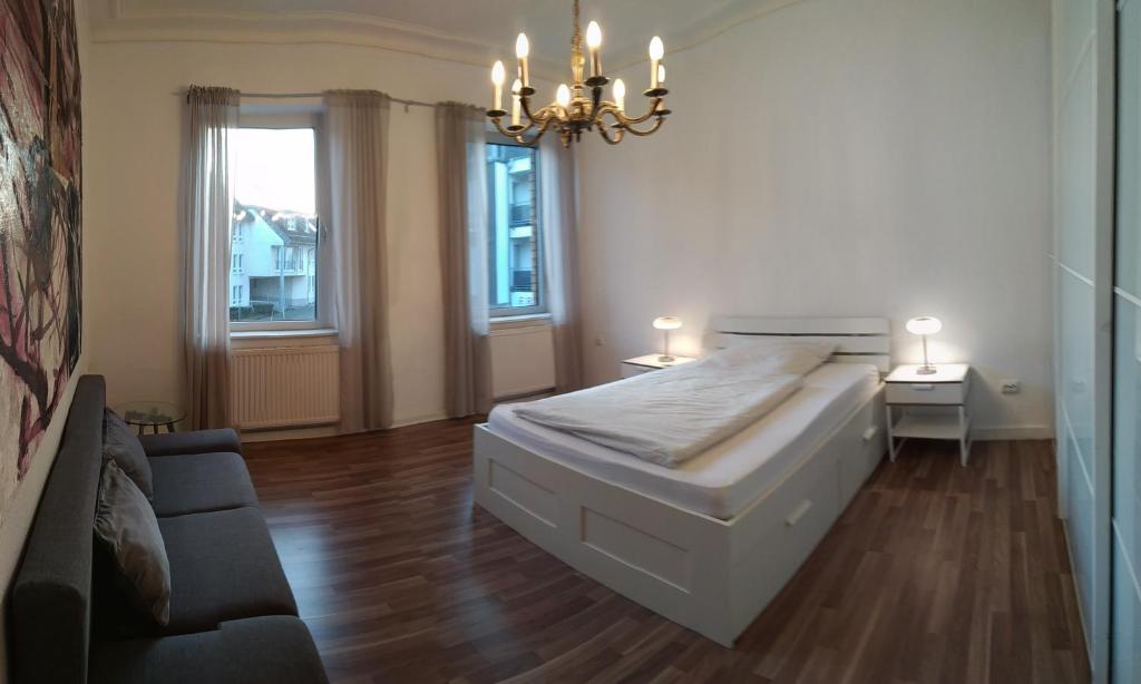 锡格堡Siegburg Apartment 1的一间卧室配有一张床、一张沙发和一个吊灯。