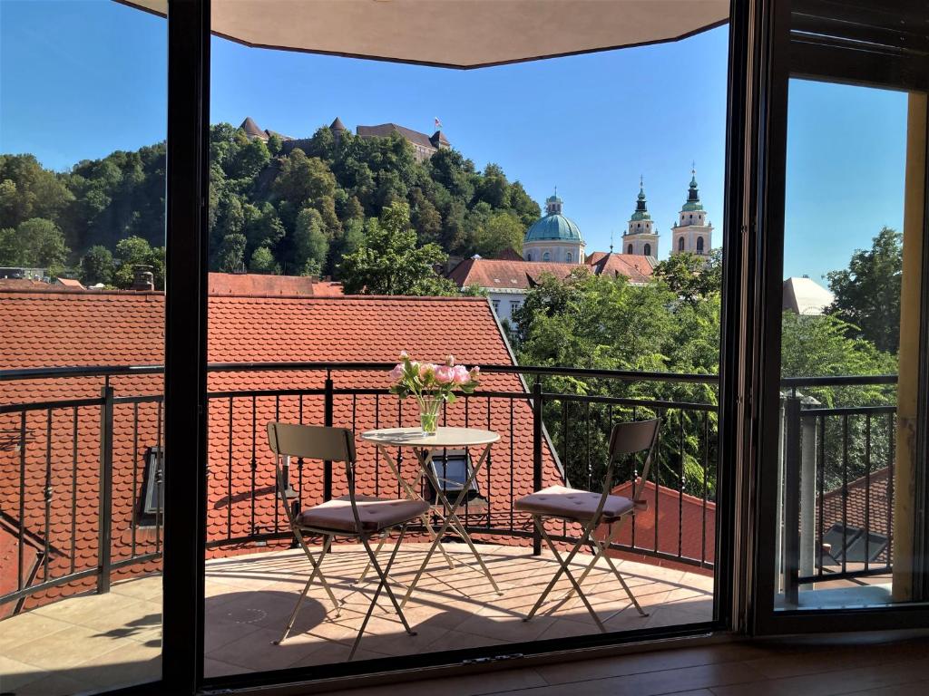 卢布尔雅那Rohrmann apartments的阳台配有两把椅子和一张鲜花桌子。