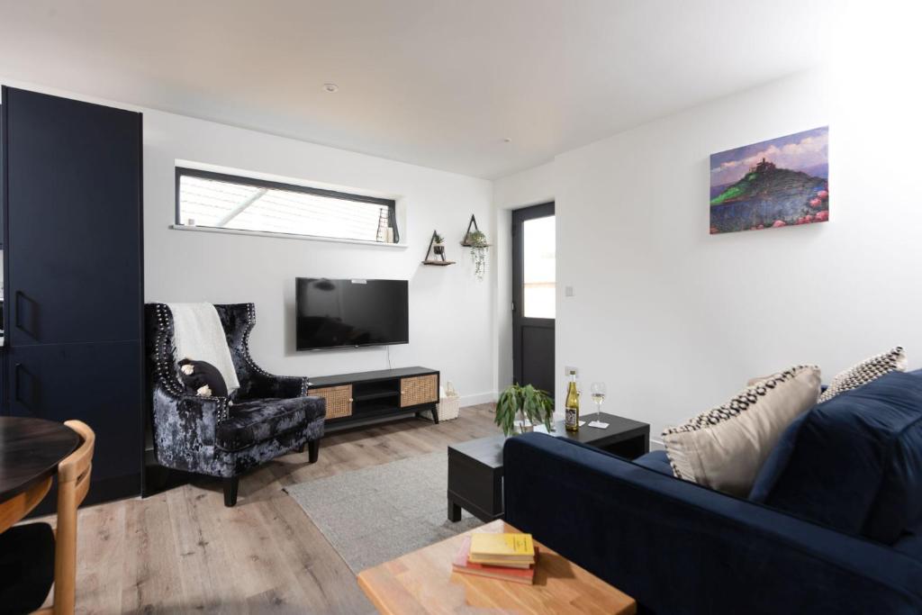 卡比斯贝Bay Dream, St Ives的客厅配有蓝色的沙发和电视
