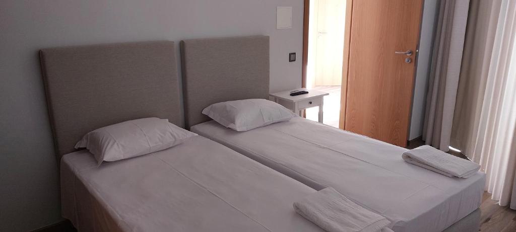 圣地亚哥-杜卡森Alojamento Local - Covas的带窗户的客房内设有两张单人床。