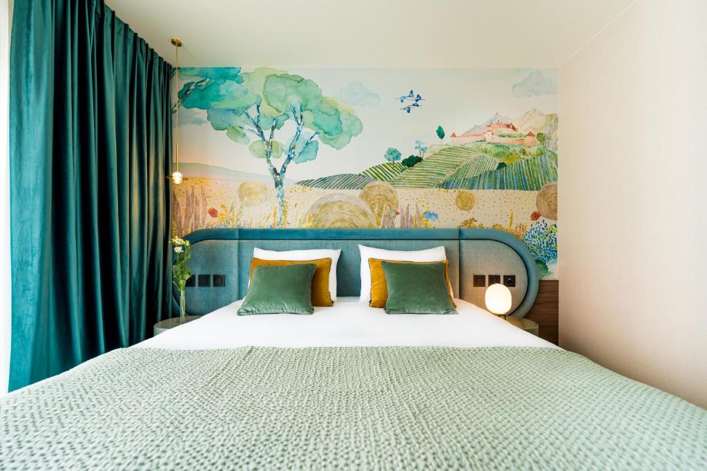布勒Hotel D Bulle - La Gruyère的一间卧室配有一张壁画床