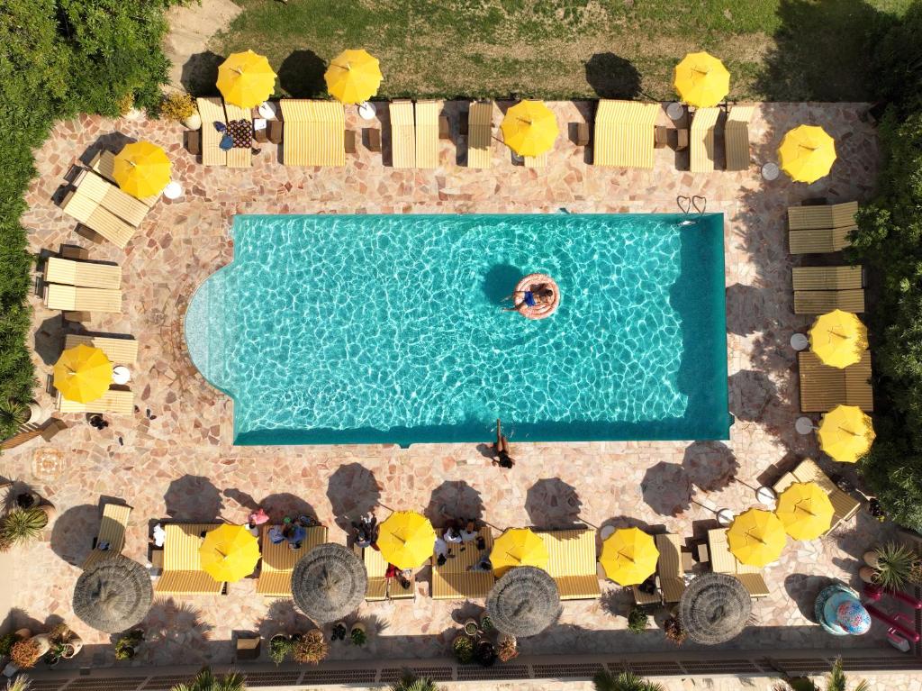 曼德琉-拉纳普勒Hotel Casarose - Cannes Mandelieu的享有游泳池的顶部景致,配有黄色遮阳伞