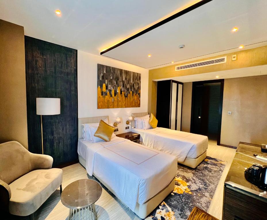 科伦坡Zest Metropole的酒店客房,设有两张床和一张沙发