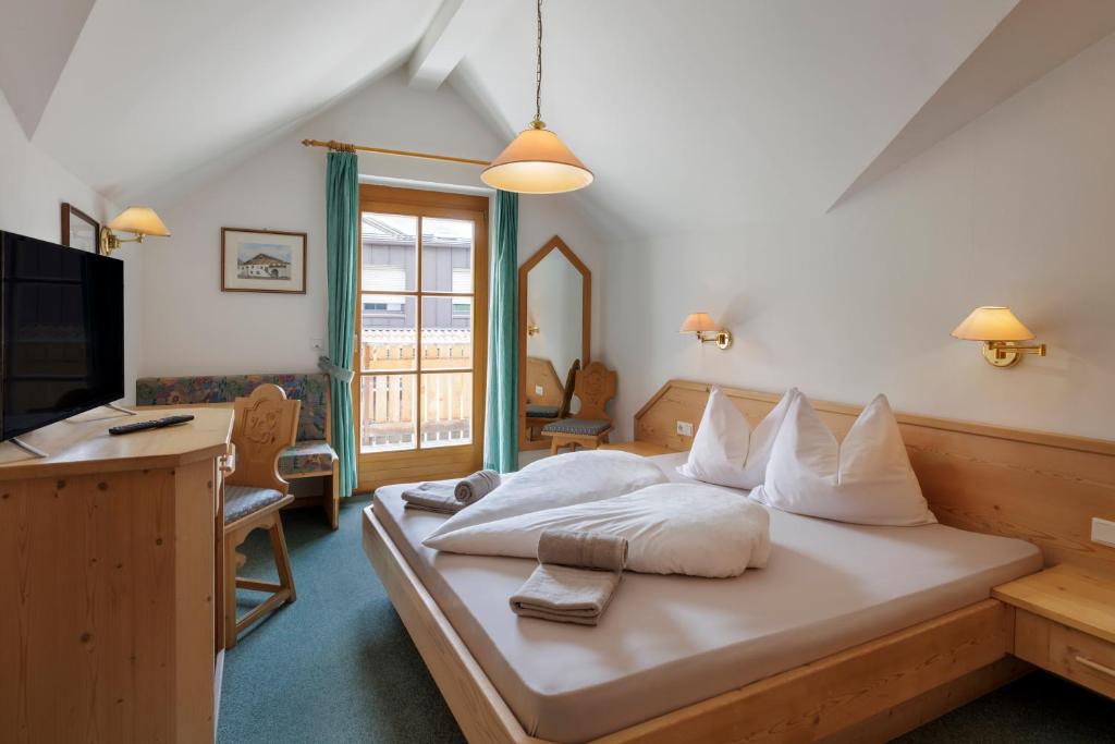 马莱斯韦诺斯塔Garni Ziernheld的一间卧室配有一张带白色枕头的床和电视。
