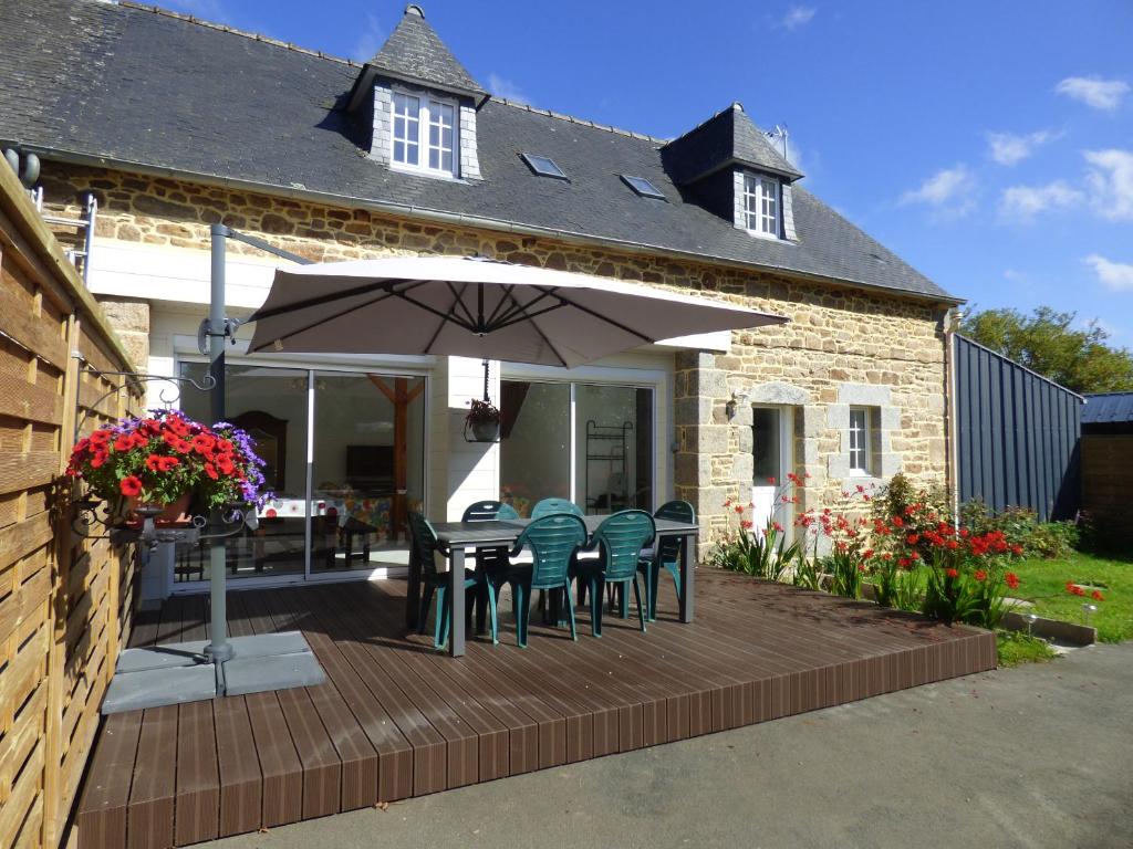 Bégardgite de kerveg的庭院配有桌椅和遮阳伞。