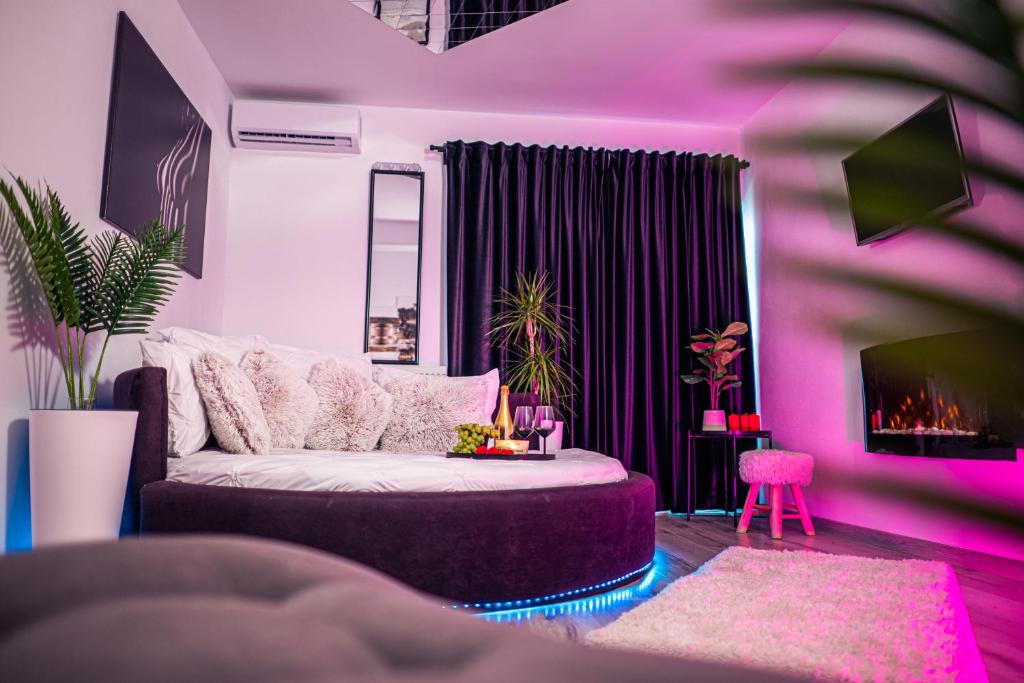 克拉约瓦Apartament Craiova Modern Space Semineu Pat Rotund的紫色的客厅配有沙发和电视