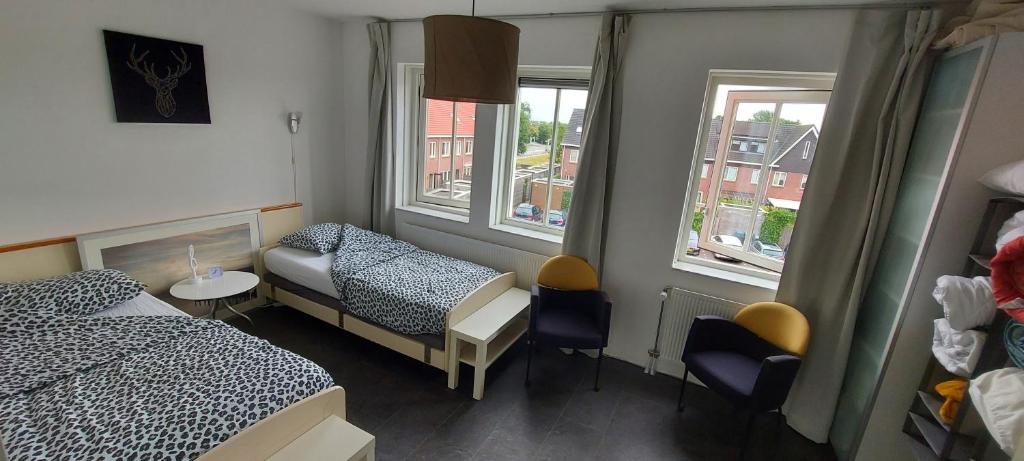梅珀尔Airbnb 'Logeren aan het plein' in het centrum van Meppel的小房间设有两张床和窗户