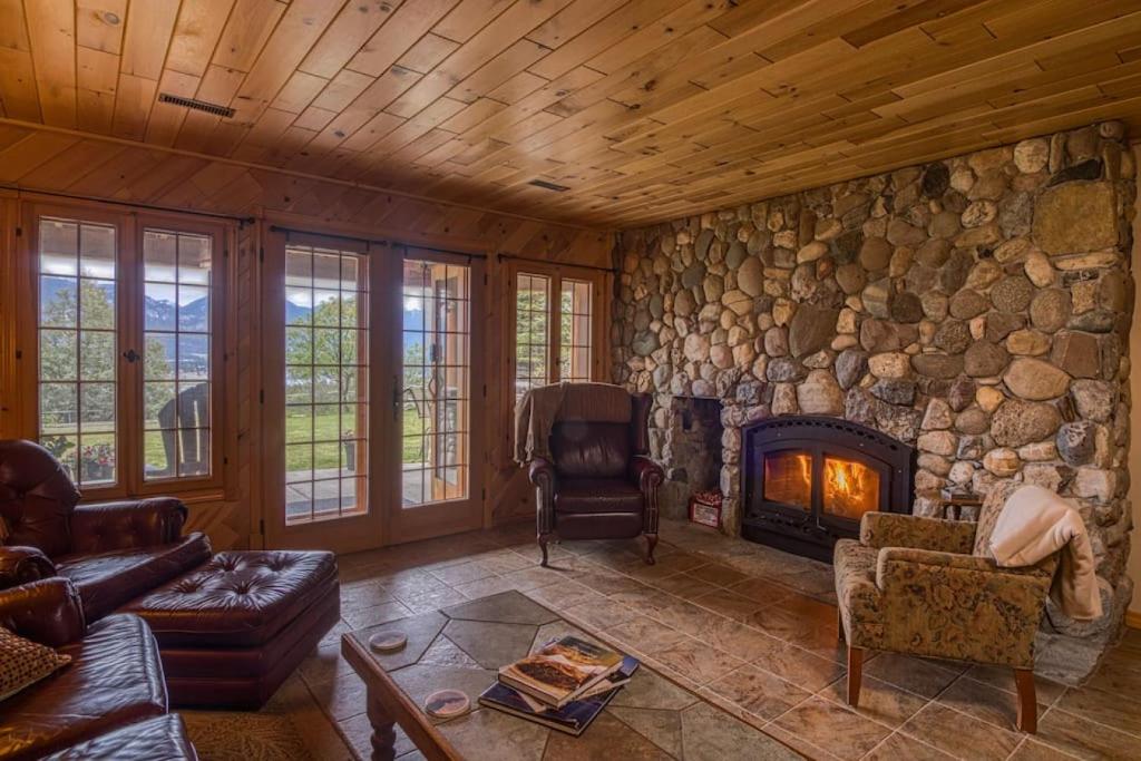 因弗米尔Pine Ridge, Log Home with Lake View and Backyard的客厅设有带壁炉的石墙