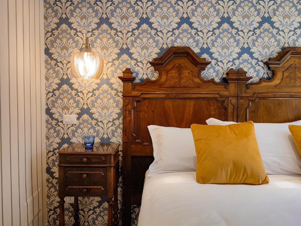贝加莫Da Pardis的一间卧室配有一张带木制床头板和边桌的床。