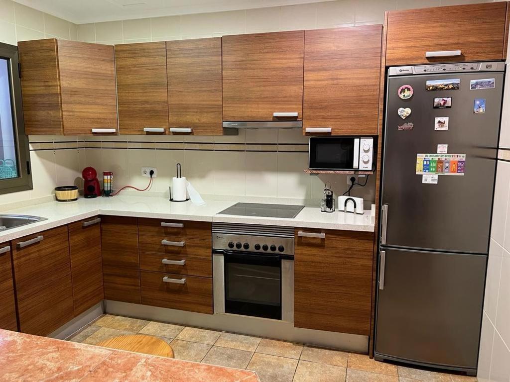 大塔拉哈尔Casa vacacional Renacer的厨房配有木制橱柜和不锈钢冰箱。