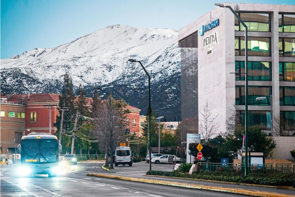 圣地亚哥Wyndham Santiago Pettra的一辆巴士沿着雪覆盖的山丘行驶在城市街道上
