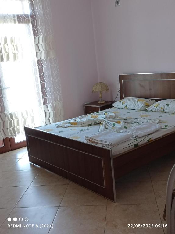 迪夫亚卡Guesthouse Fatos Biti的一间卧室配有一张木架大床