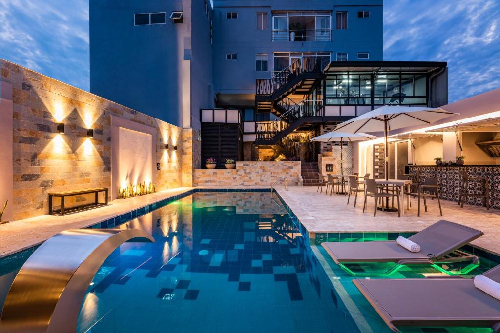 巴兰卡韦梅哈Hotel Elite的一座带桌椅的游泳池位于大楼旁