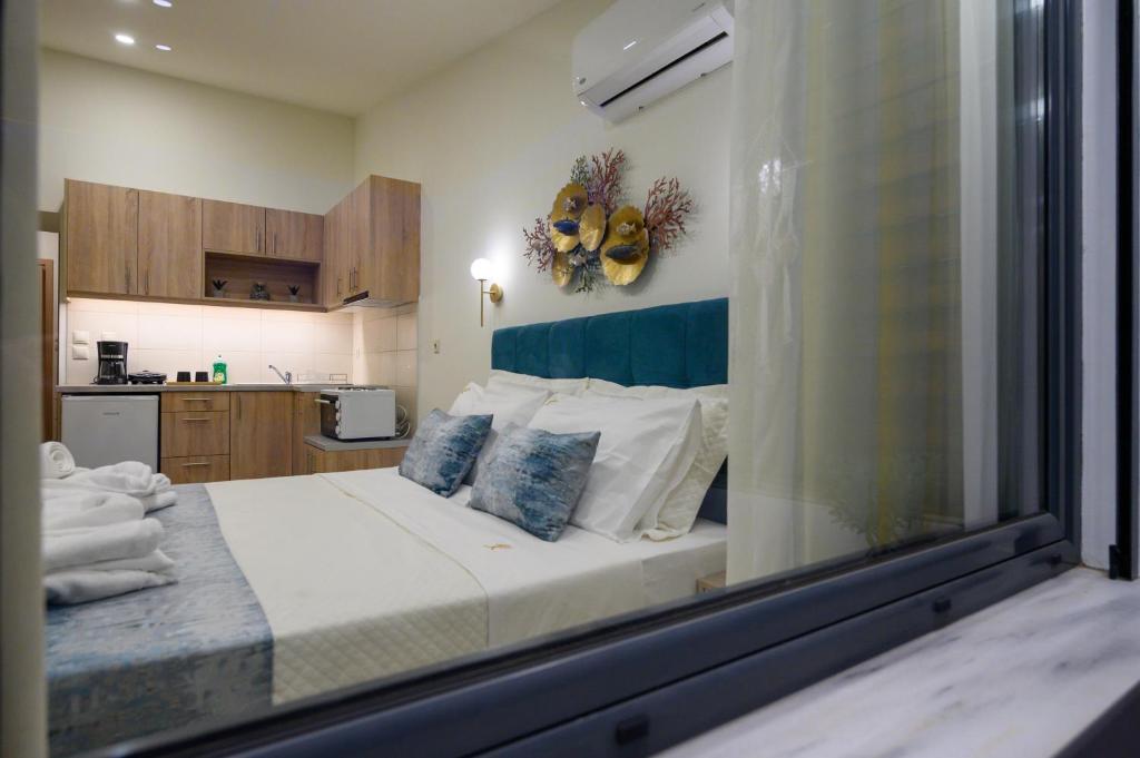 卡拉马塔Kalypso Apartments的一间卧室配有一张带蓝白色枕头的大床