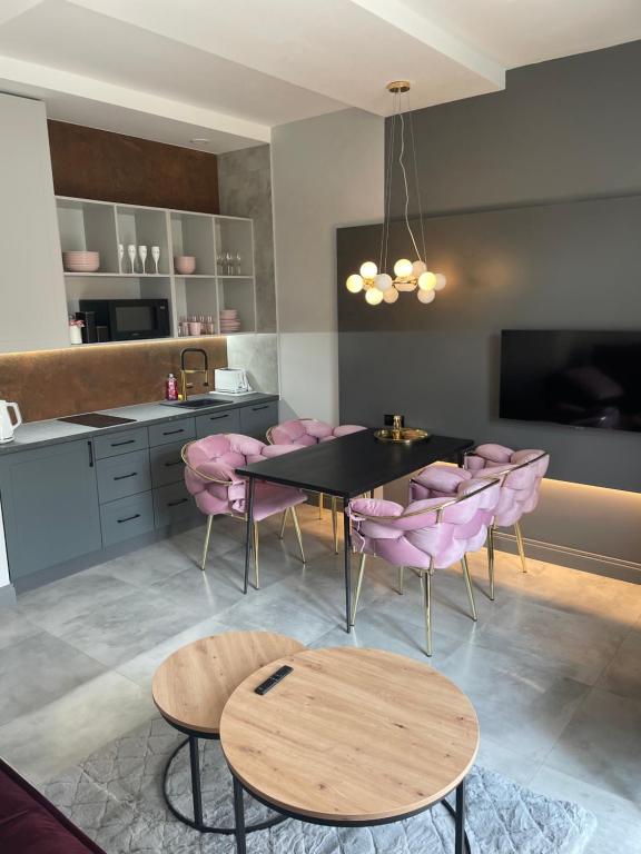 桑多梅日Apartament na Starówce的一间带桌子和粉红色椅子的用餐室