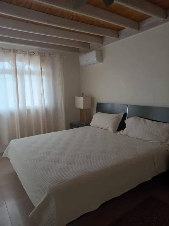 拉罗马纳casa maria的卧室设有一张白色大床和一扇窗户。
