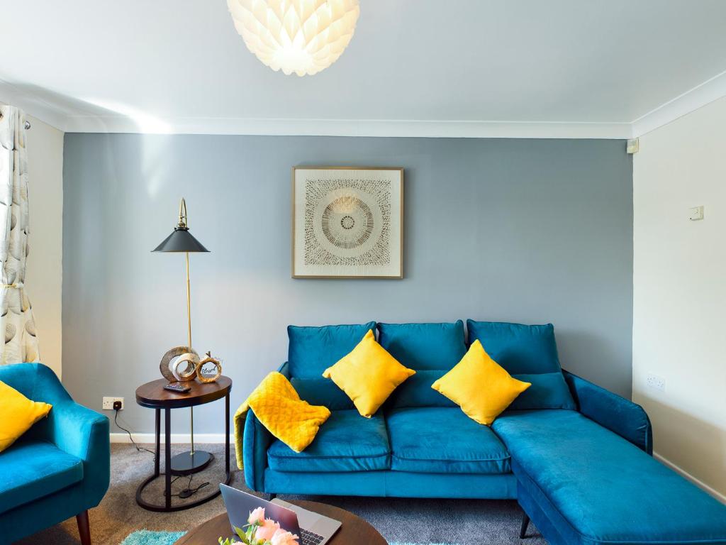 特尔福德247 Serviced Accommodation in Telford- 3BR HOUSE的客厅配有蓝色沙发及黄色枕头