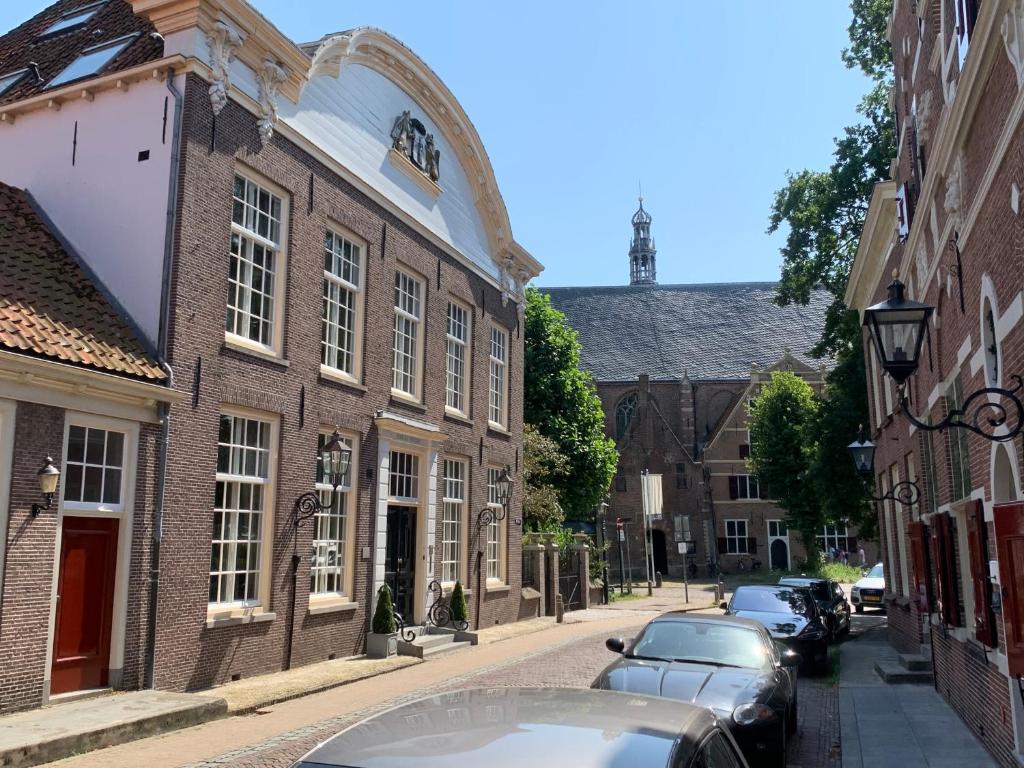 蒙尼肯丹Fortuna Spinoza的停在建筑物旁边的街道上的一排汽车