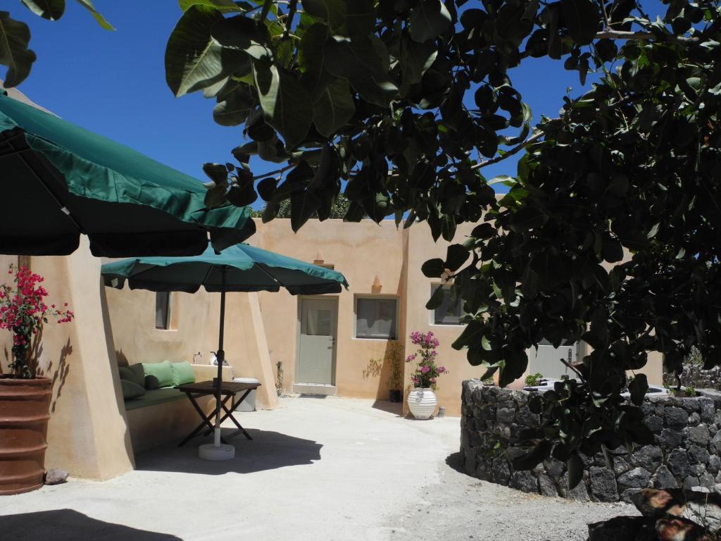 Éxo GoniáMagma & Tefra的一个带桌子和遮阳伞的庭院