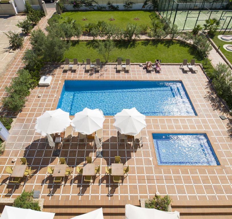 普拉亚登博萨Bon Sol Prestige - AB Group的享有带桌子和遮阳伞的游泳池的顶部景致