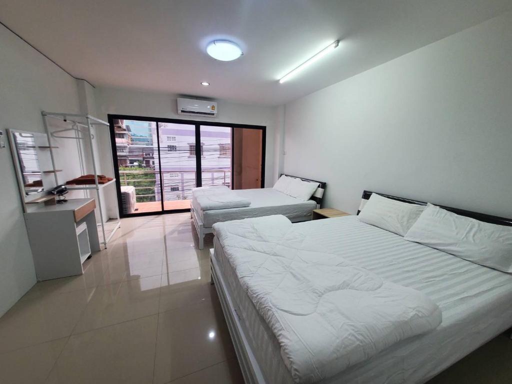 合艾Khoksametchun Hostel的一间有两张床和厨房的酒店房间