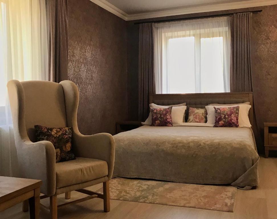 FedorovkaСтарий Тудорів的卧室配有床、椅子和窗户。