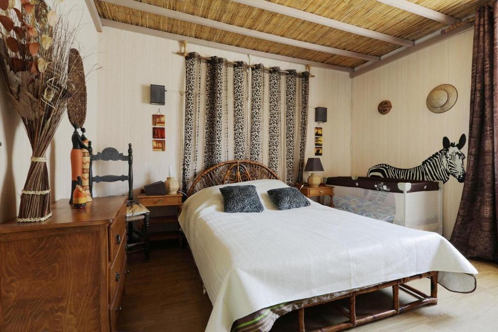 Caudiès-de-FenouillèdesGîte les Hirondelles的卧室配有一张床,墙上挂着斑马