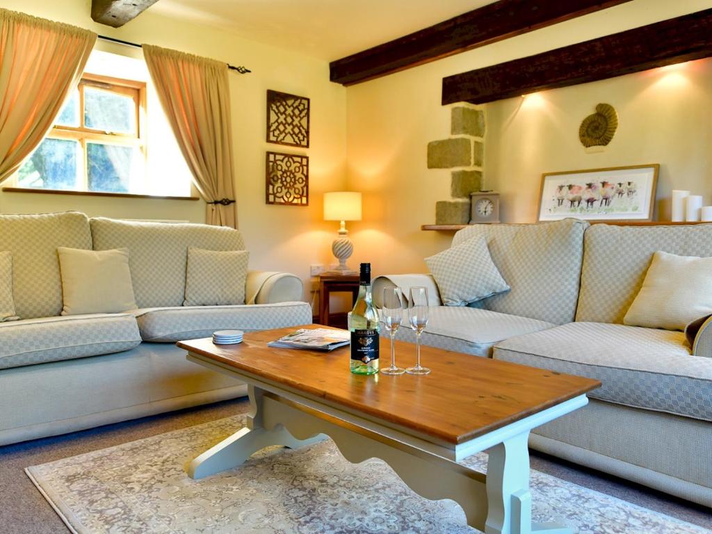 Pass the Keys Cosy Rural 2 Bed Barn conversion close to Beach的客厅配有沙发和带酒杯的桌子