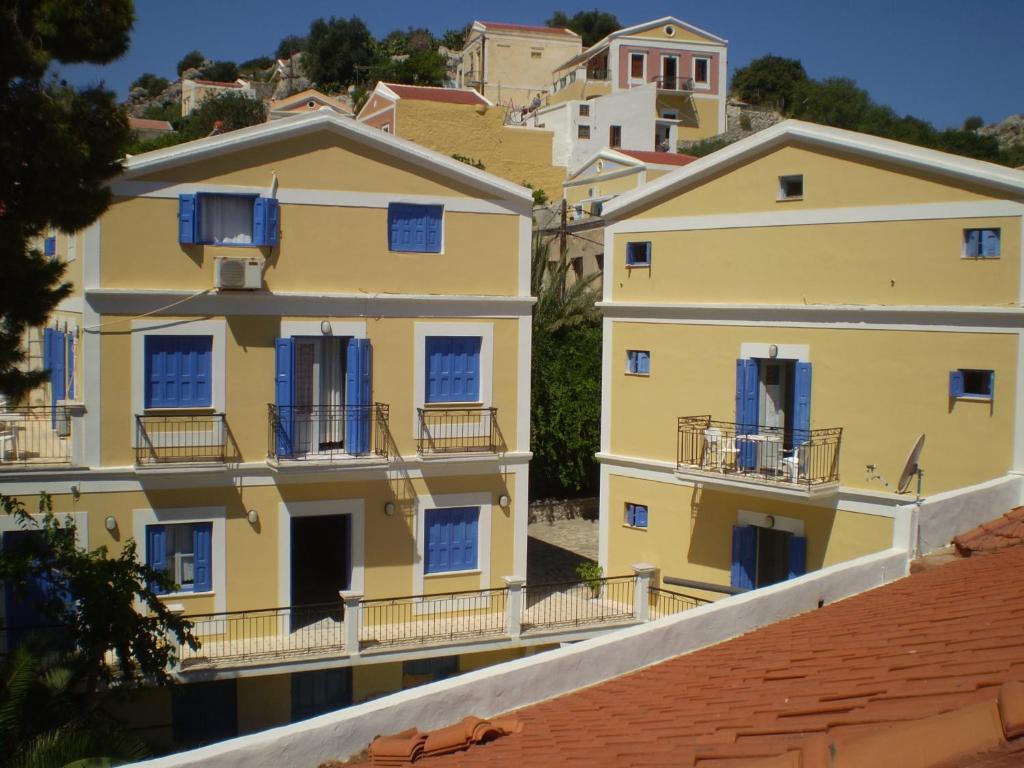 锡米阿纳斯塔西娅酒店的一排带蓝色百叶窗的黄色房子