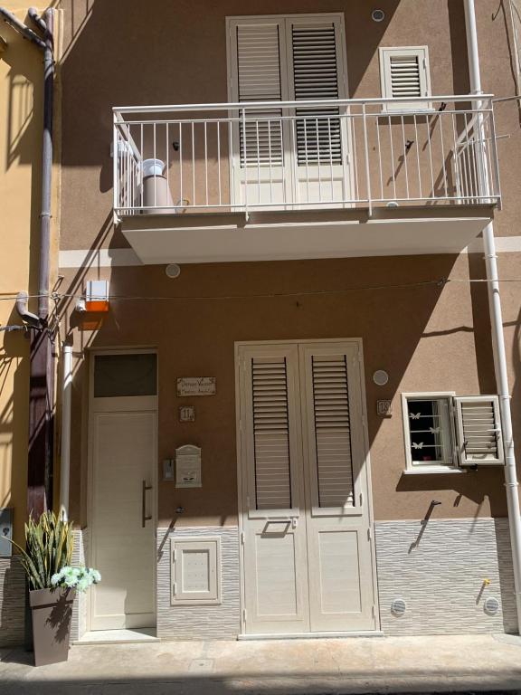 巴格里亚Denise Vacanze - Monolocali arredati的公寓大楼设有阳台和门。