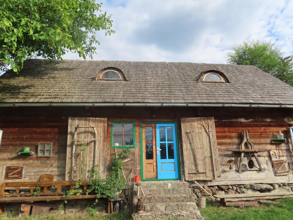 BrebBabou Maramures的一间古老的小木屋,设有蓝色的门