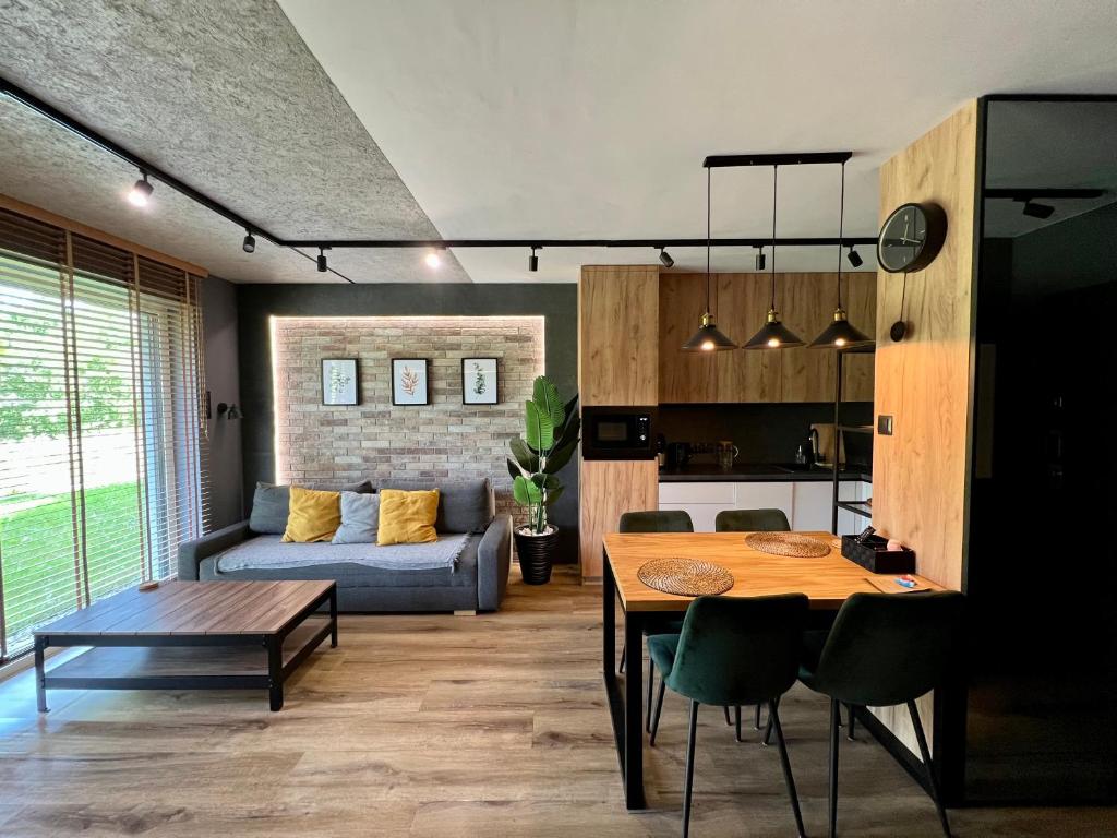 凯尔采Loft Klonowa - Apartament z garażem的客厅配有桌子和沙发